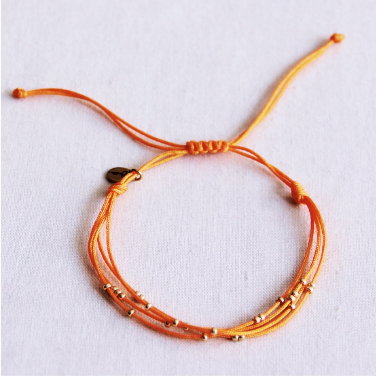 Viervoudige satijnen armband met kralen - oranje