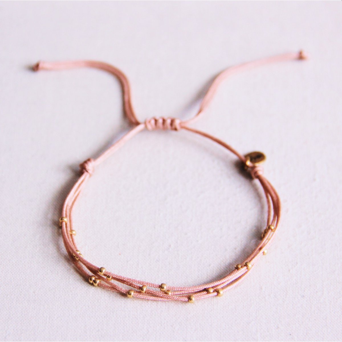 Viervoudige satijnen armband met kralen - oud roze