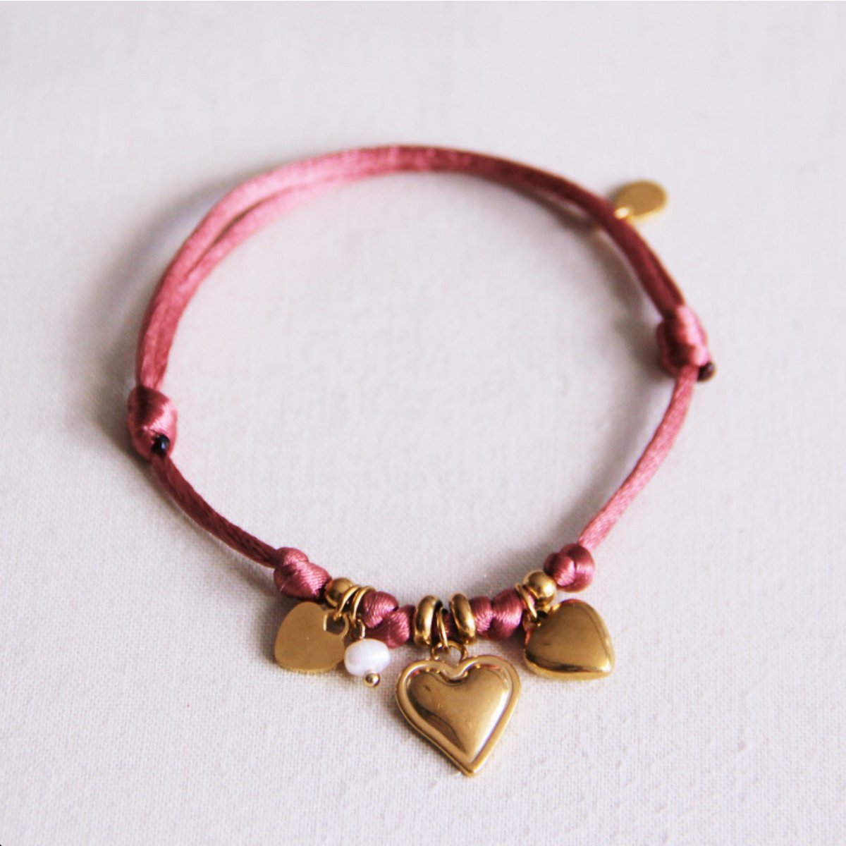 Satijnen bedelarmband met harten en kleine parel - stoffig roze