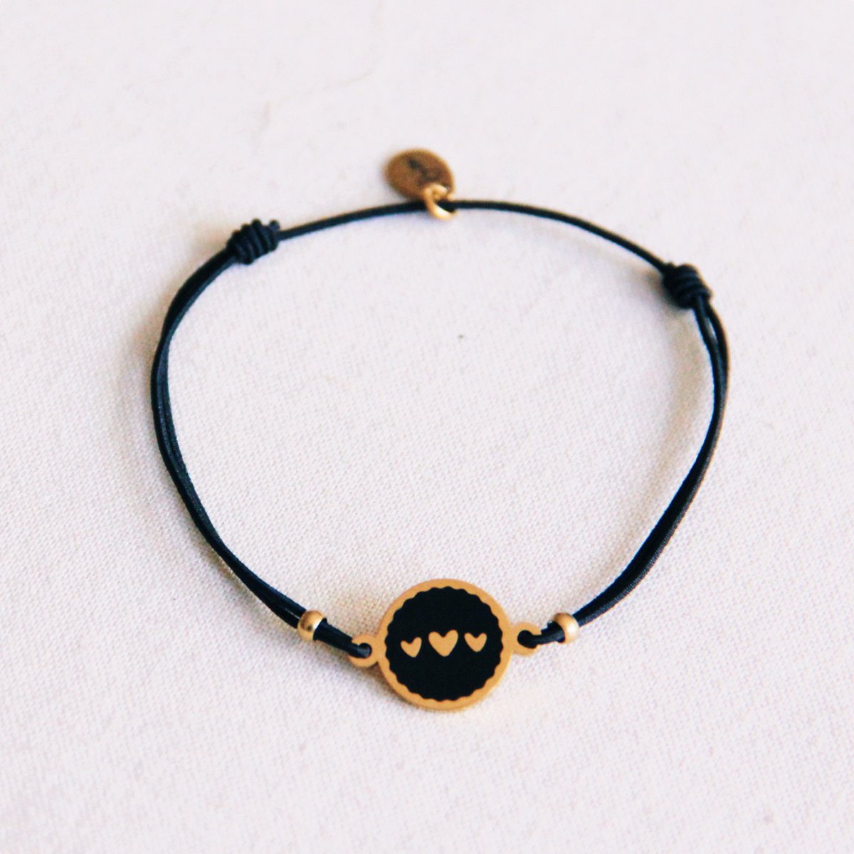 Elastiek armbandje met 3 hartjes bedeltjes - zwart/goud